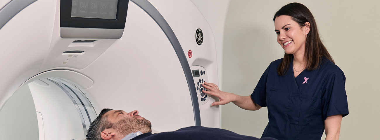 Radiograf snakker med pasient i maskin 